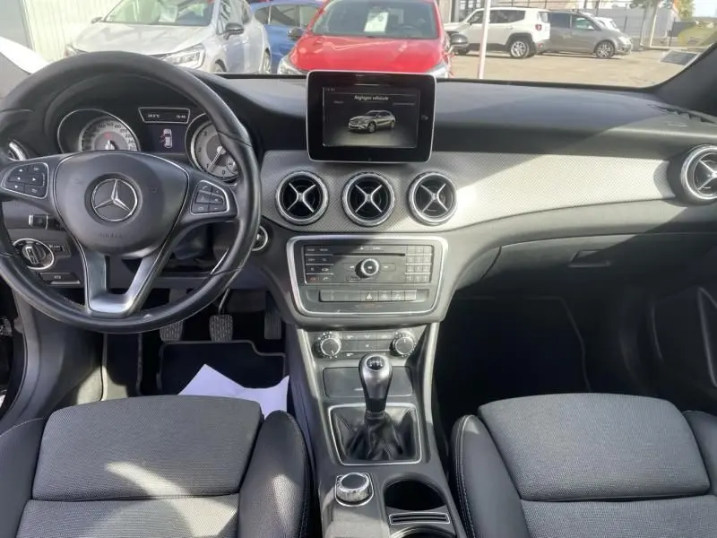 Intérieur de Mercedes GLA 200 D Sensation 2017, vue frontale du tableau de bord avec volant, écran et levier de vitesse manuel.