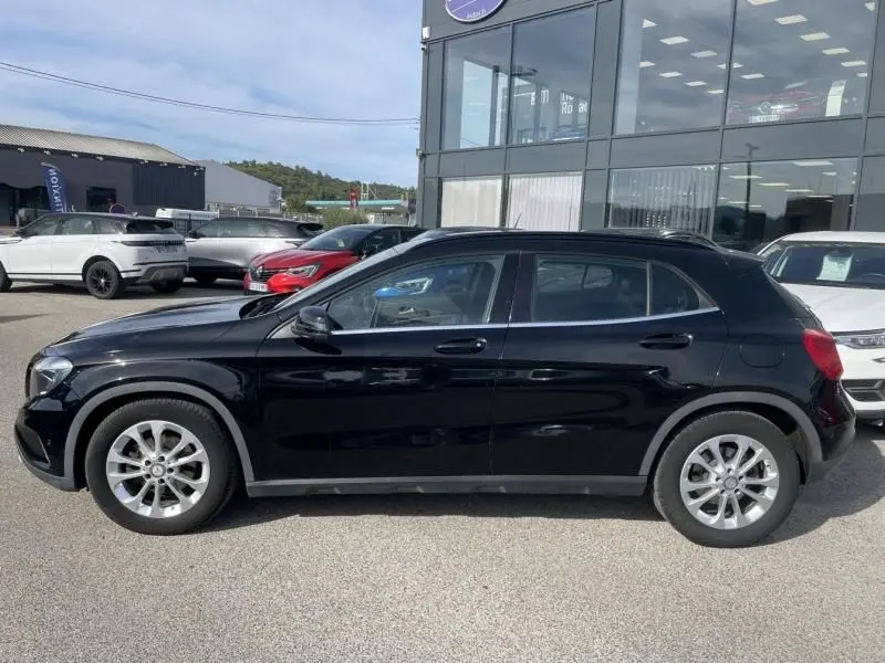 Vue latérale côté gauche d'un Mercedes GLA 200 D Sensation noir de 2017, avec jantes alliage et carrosserie brillante.