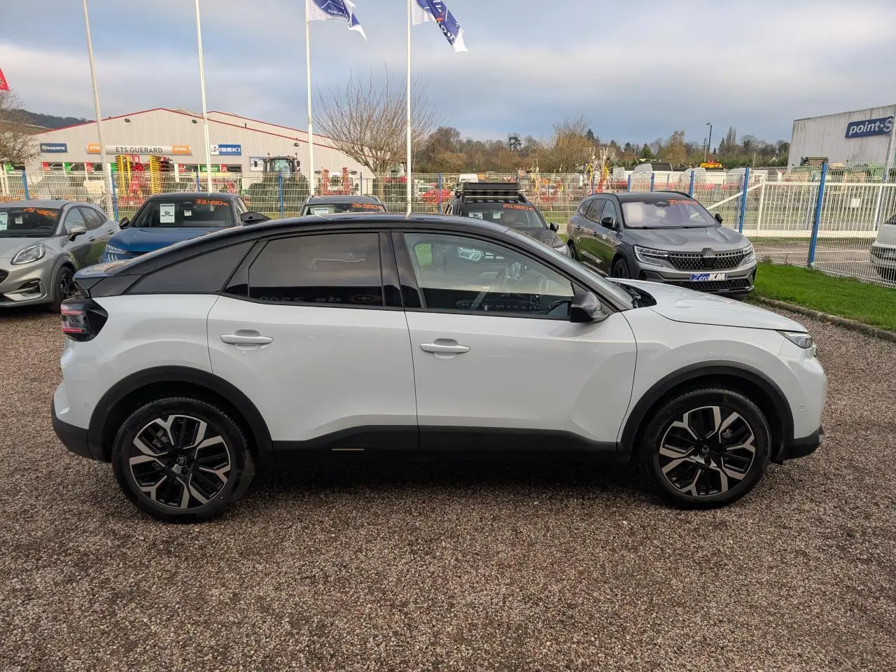 Profil côté gauche d'une Citroën C4 blanche 2025 avec toit noir Perla Nera et jantes alliage 18 pouces.