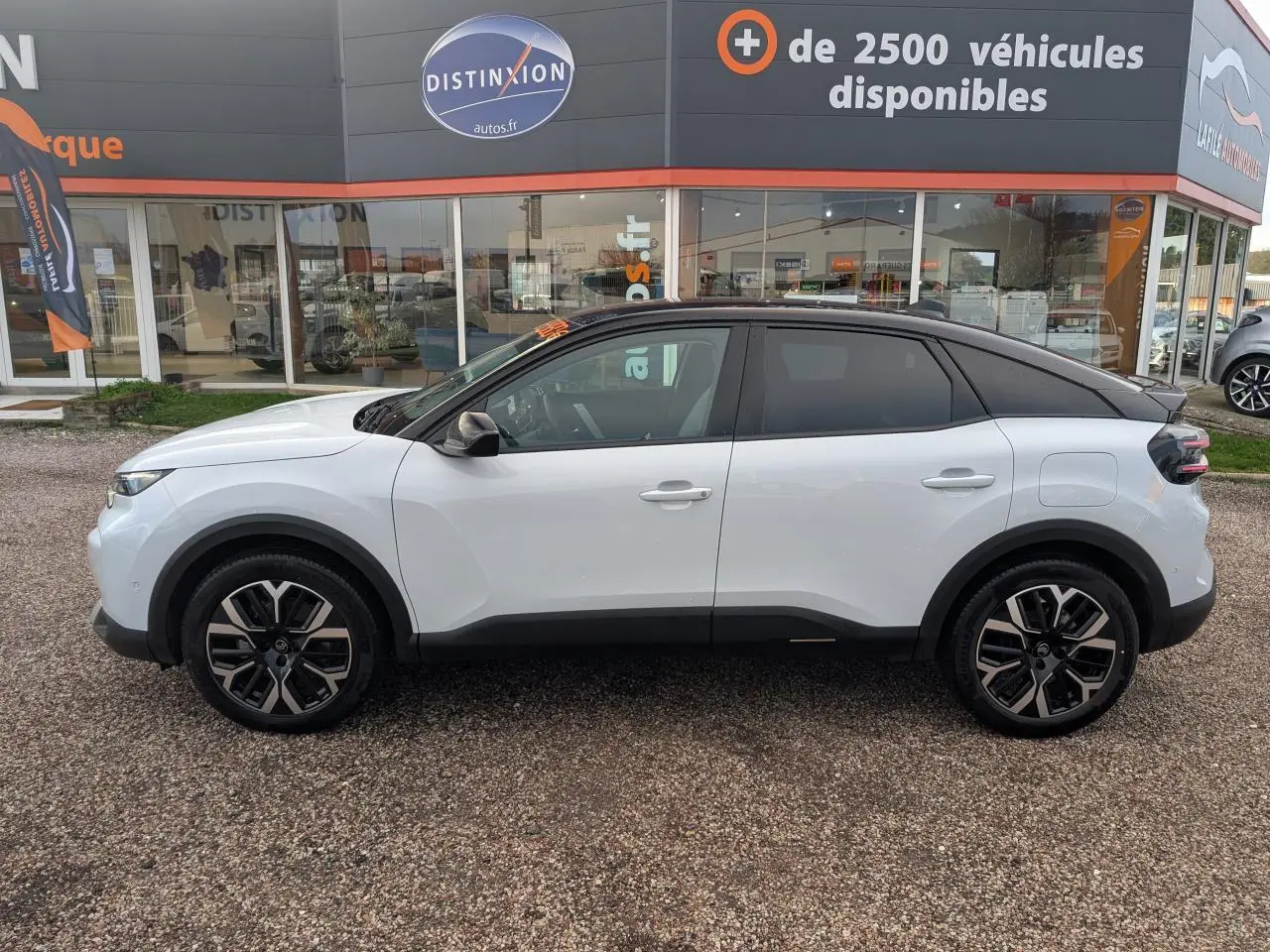 Profil côté gauche d'une Citroën C4 blanche 2025 avec toit noir bi-ton et jantes alliage 18 pouces.