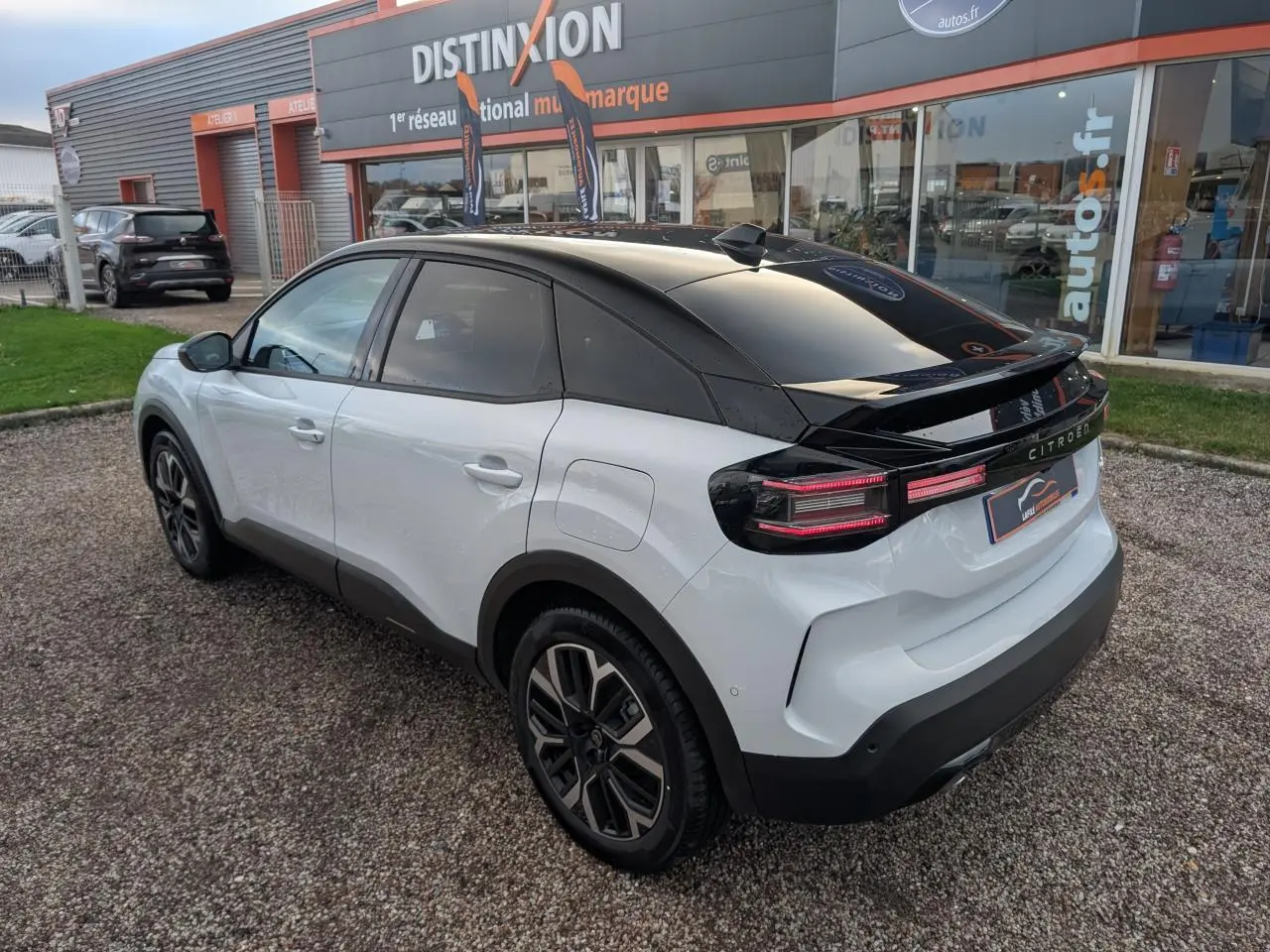 Vue 3/4 arrière droite d'une Citroën C4 blanche avec toit noir Perla Nera et jantes alliage 18 pouces.