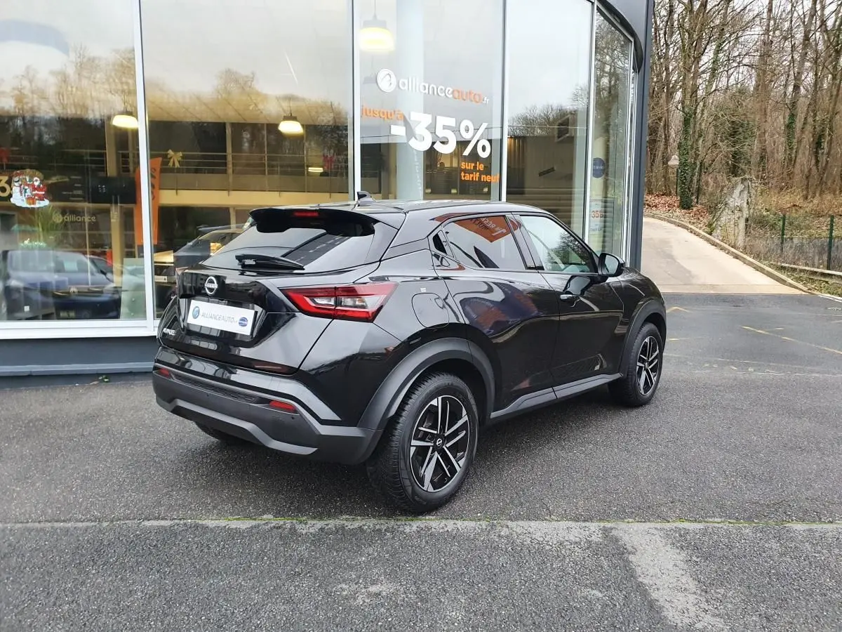 Vue 3/4 arrière droite du Nissan Juke noir métallisé 2025 avec jantes alliage 17'' et antenne aileron de requin.