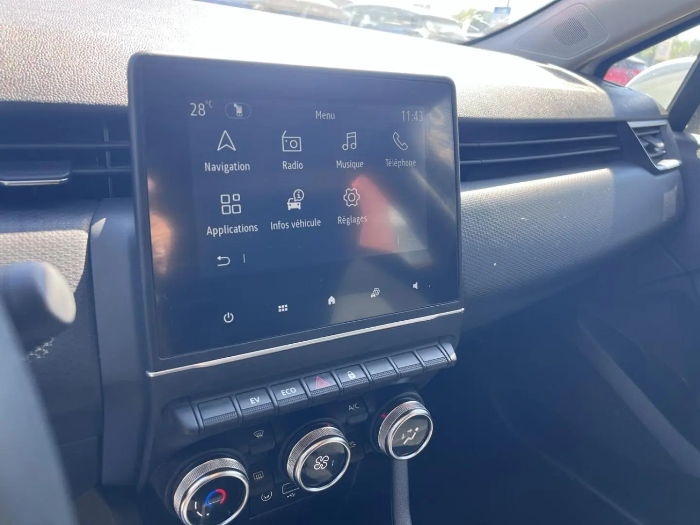 Vue intérieure du tableau de bord de la Renault Clio 1.6 E-Tech 2021, écran tactile et commandes de climatisation visibles.