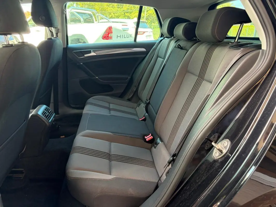 Vue intérieure côté droit des sièges arrière en tissu gris et noir de la Volkswagen Golf 7 noire de 2016.