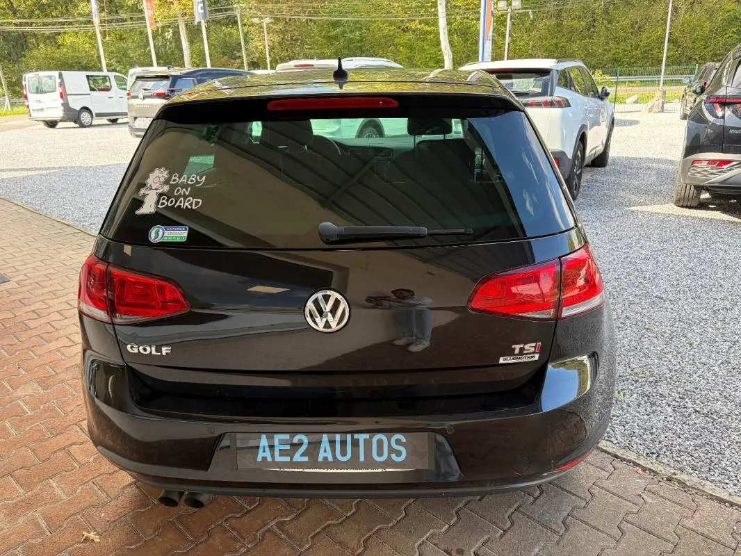 Vue arrière d’une Volkswagen Golf 7 noire de 2016 avec badge TSI et autocollant Baby on Board sur la vitre arrière.