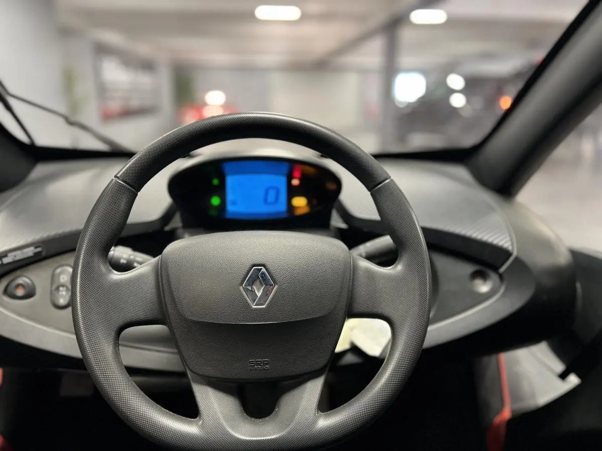 Vue intérieure centrée sur le volant noir de la Renault Twizy Intens 2019 avec tableau de bord digital bleu.