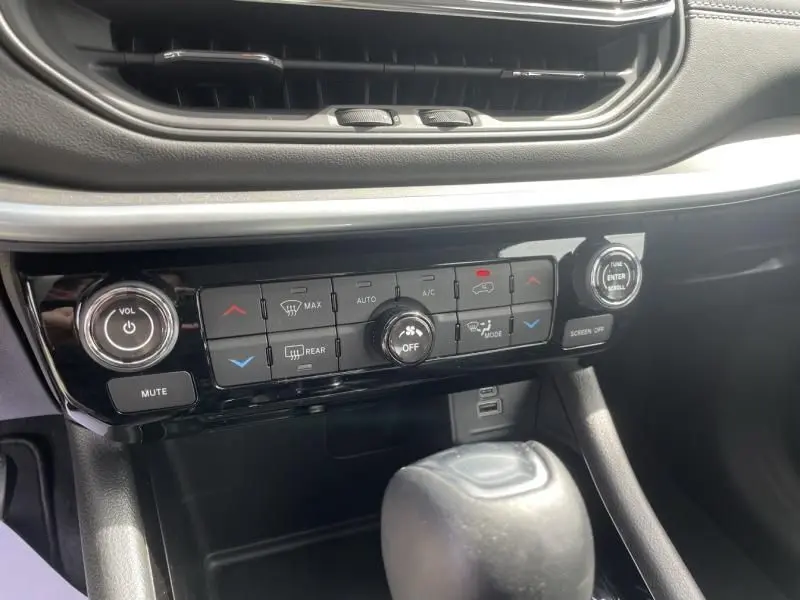 Panneau de commande de climatisation et audio du Jeep Compass blanc 2024, vue rapprochée de la console centrale.