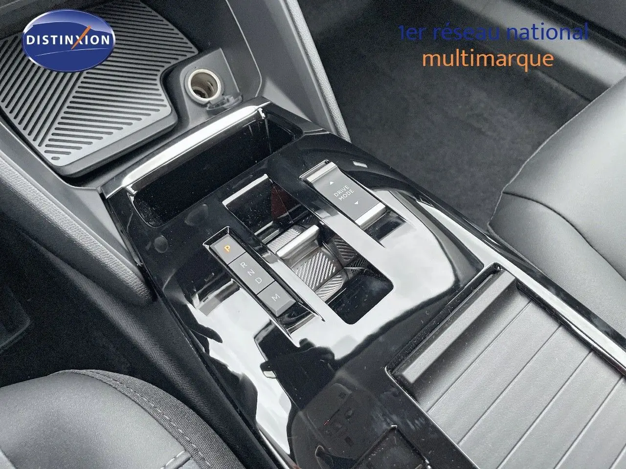 Gros plan sur la console centrale noire brillante de la Citroën C4 2024 avec levier de vitesses automatique et bouton Drive Mode.