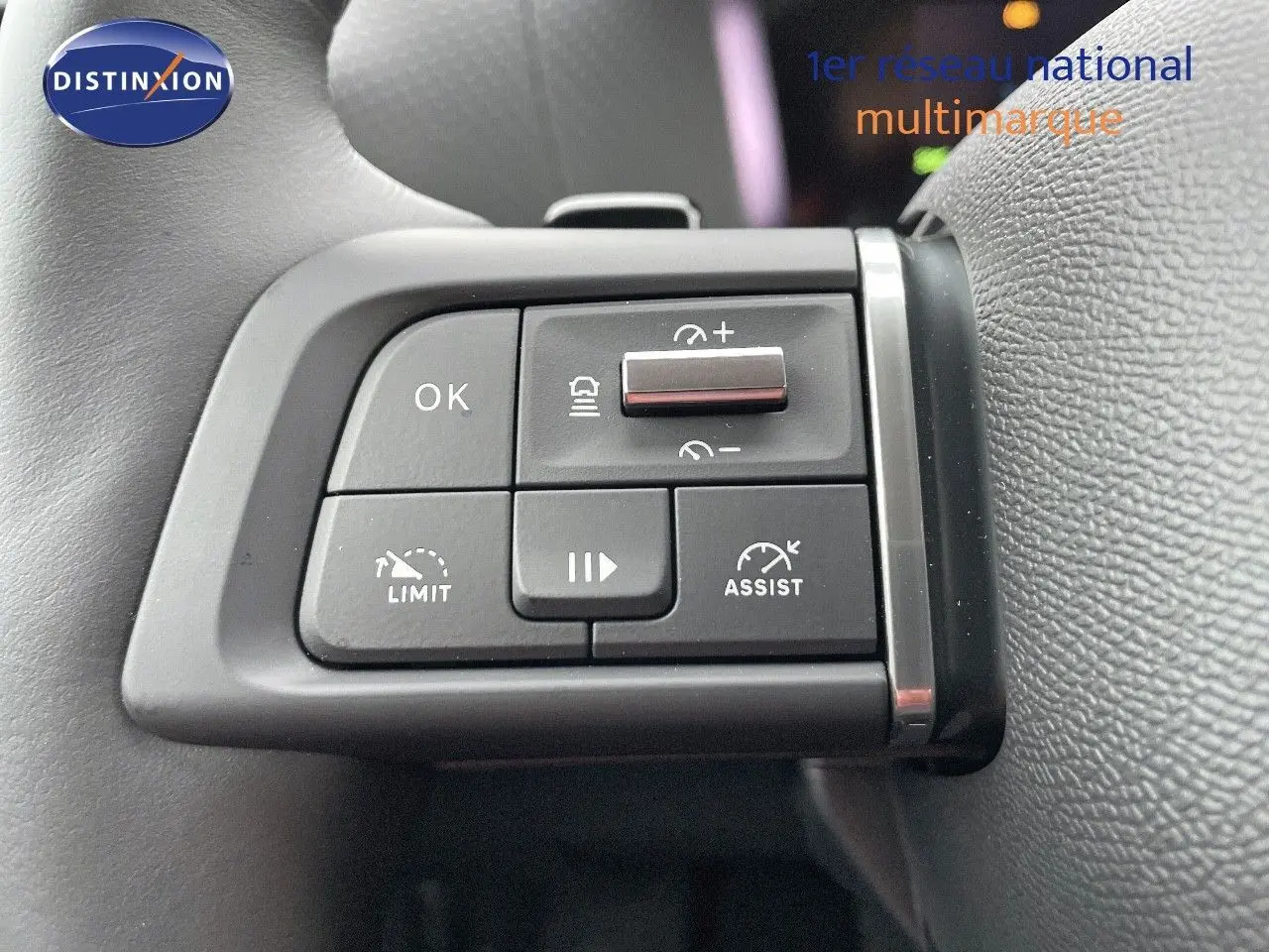 Gros plan sur les commandes au volant du Citroën C4 2024 gris platinium, avec boutons de régulateur et assistant de conduite.