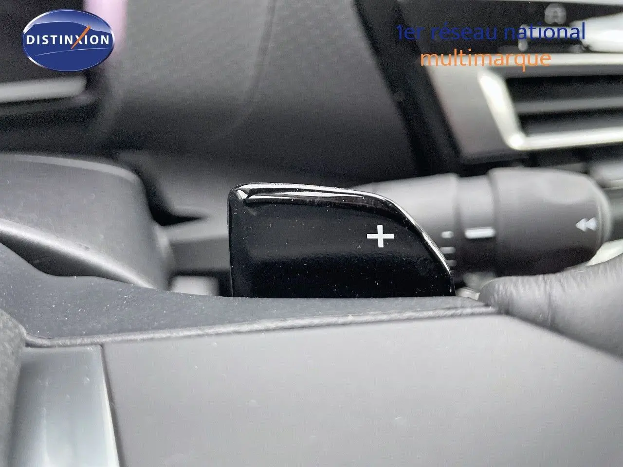 Gros plan sur la palette de changement de vitesse "+" côté droit du volant d'une Citroën C4 gris platinium 2024.