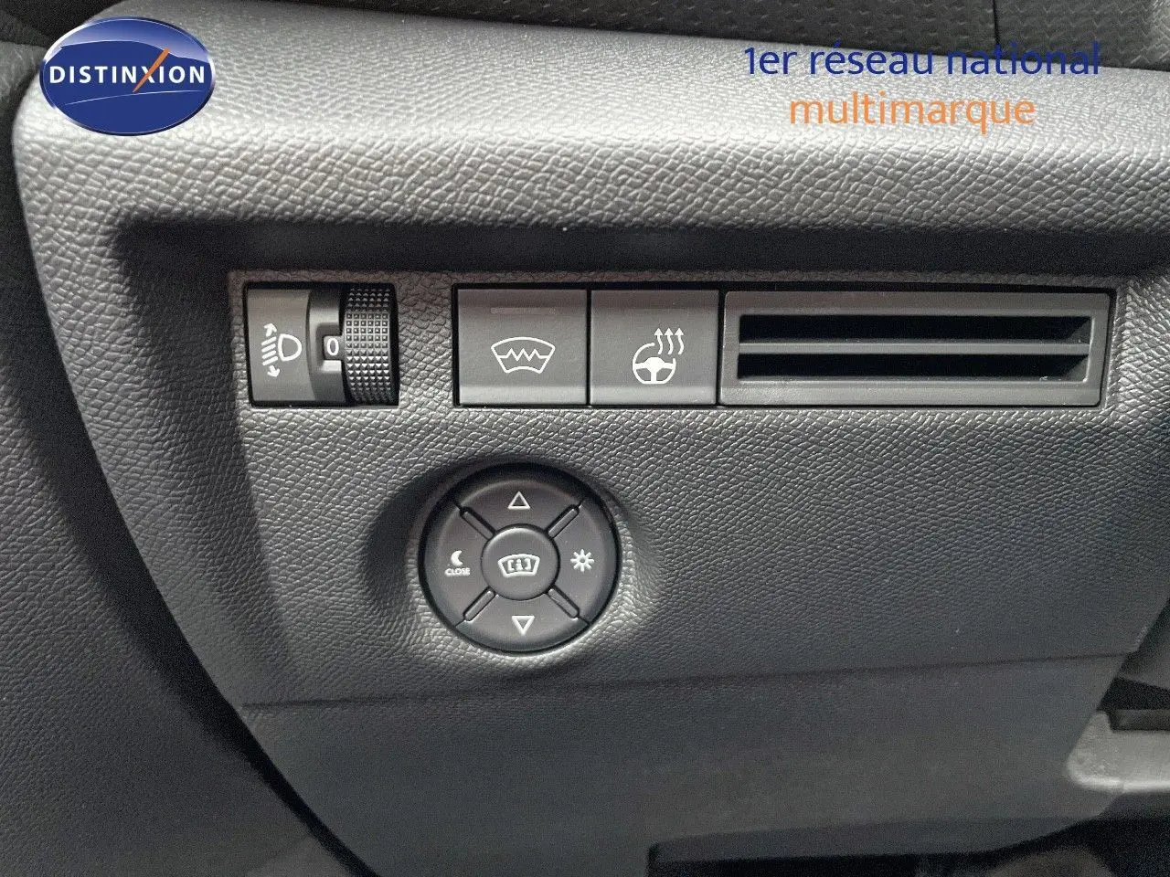 Détail des commandes d'éclairage et chauffage du volant sur le tableau de bord noir d'une Citroën C4 gris platinium.
