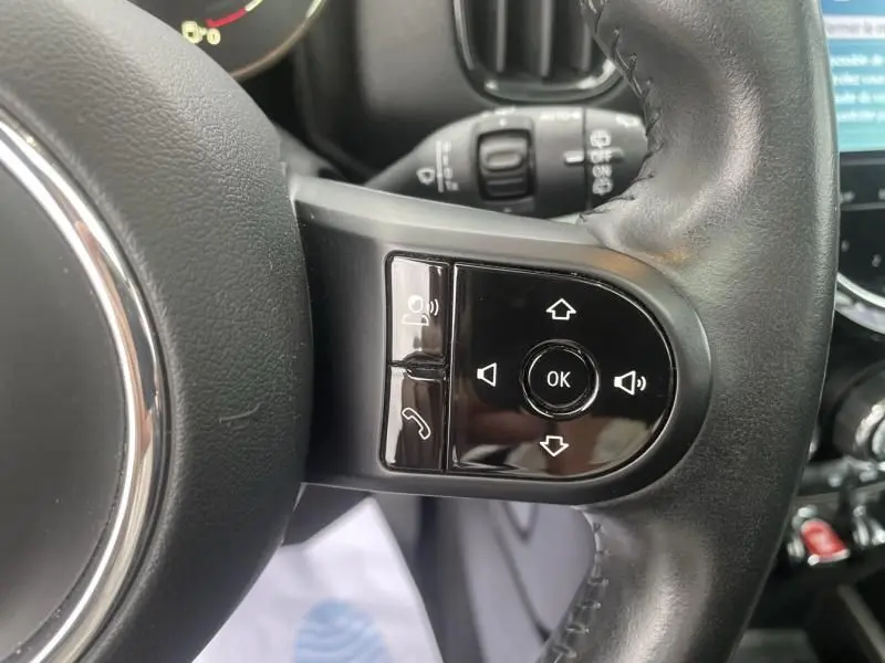 Gros plan sur les commandes multifonctions du volant en cuir noir du MINI Countryman Cooper 136 gris, modèle 2021.