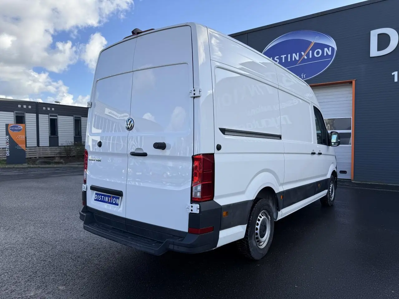 Volkswagen Crafter fourgon blanc vu en 3/4 arrière droit, toit haut H3, porte coulissante droite visible.