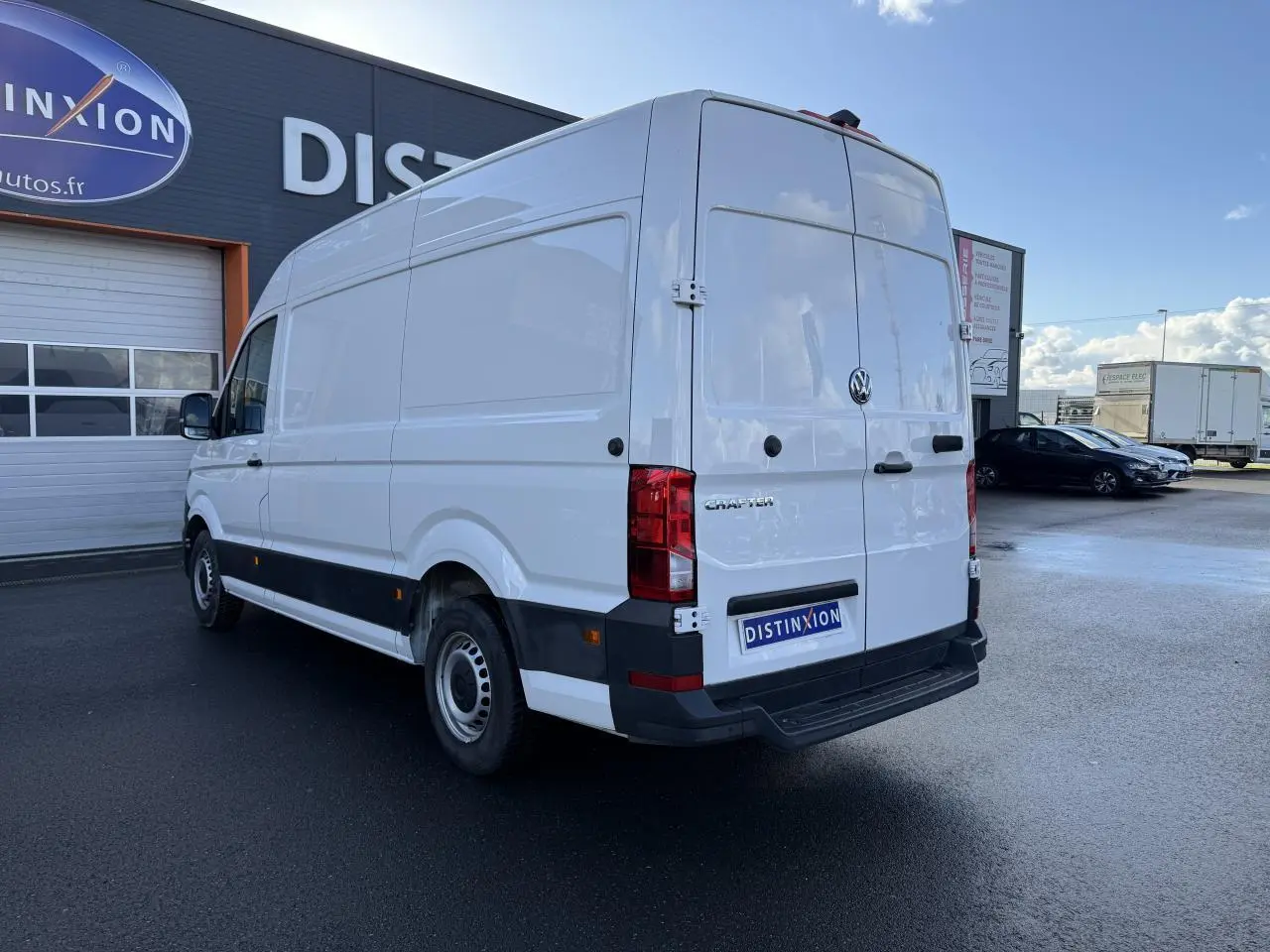 Vue 3/4 arrière droite d'un Volkswagen Crafter blanc, fourgon utilitaire avec toit haut et porte coulissante à droite.