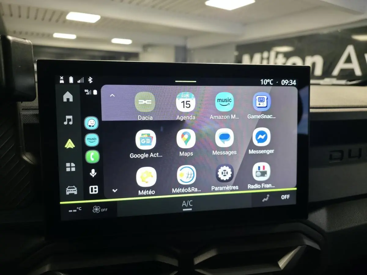 Vue rapprochée de l’écran tactile central 10 pouces du Dacia Duster 1.6 Hybrid noir, affichant les applications connectées.