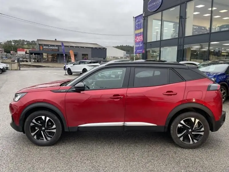 Profil côté gauche du Peugeot 2008 130 GT-LINE 2022 en rouge métal avec toit noir et jantes alliage bicolores.