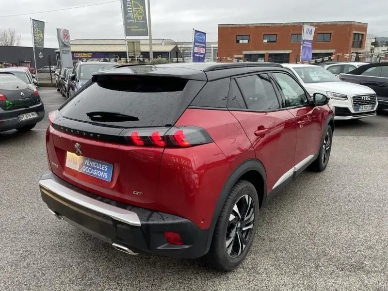 Peugeot 2008 130 GT-LINE rouge métal vue 3/4 arrière droit avec toit noir et feux arrière LED distinctifs.