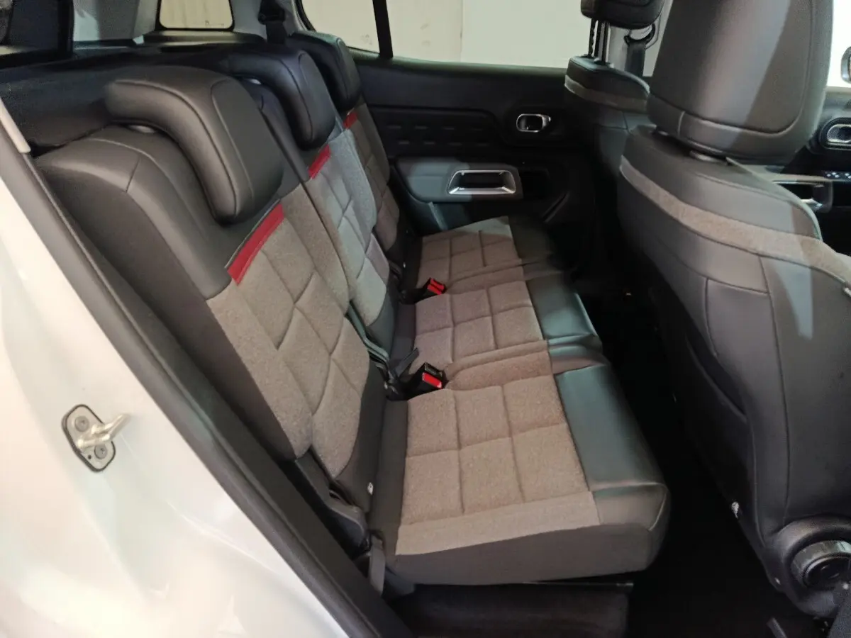 Vue intérieure côté gauche des sièges arrière gris et noirs avec surpiqûres rouges du Citroën C5 Aircross Hybrid blanc 2021.