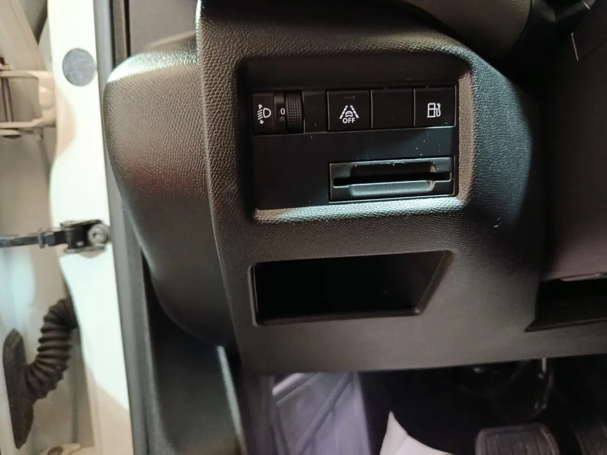 Détail intérieur côté gauche du tableau de bord noir du Citroën C5 Aircross Hybrid blanc, avec commandes d’éclairage et aide à la conduite.