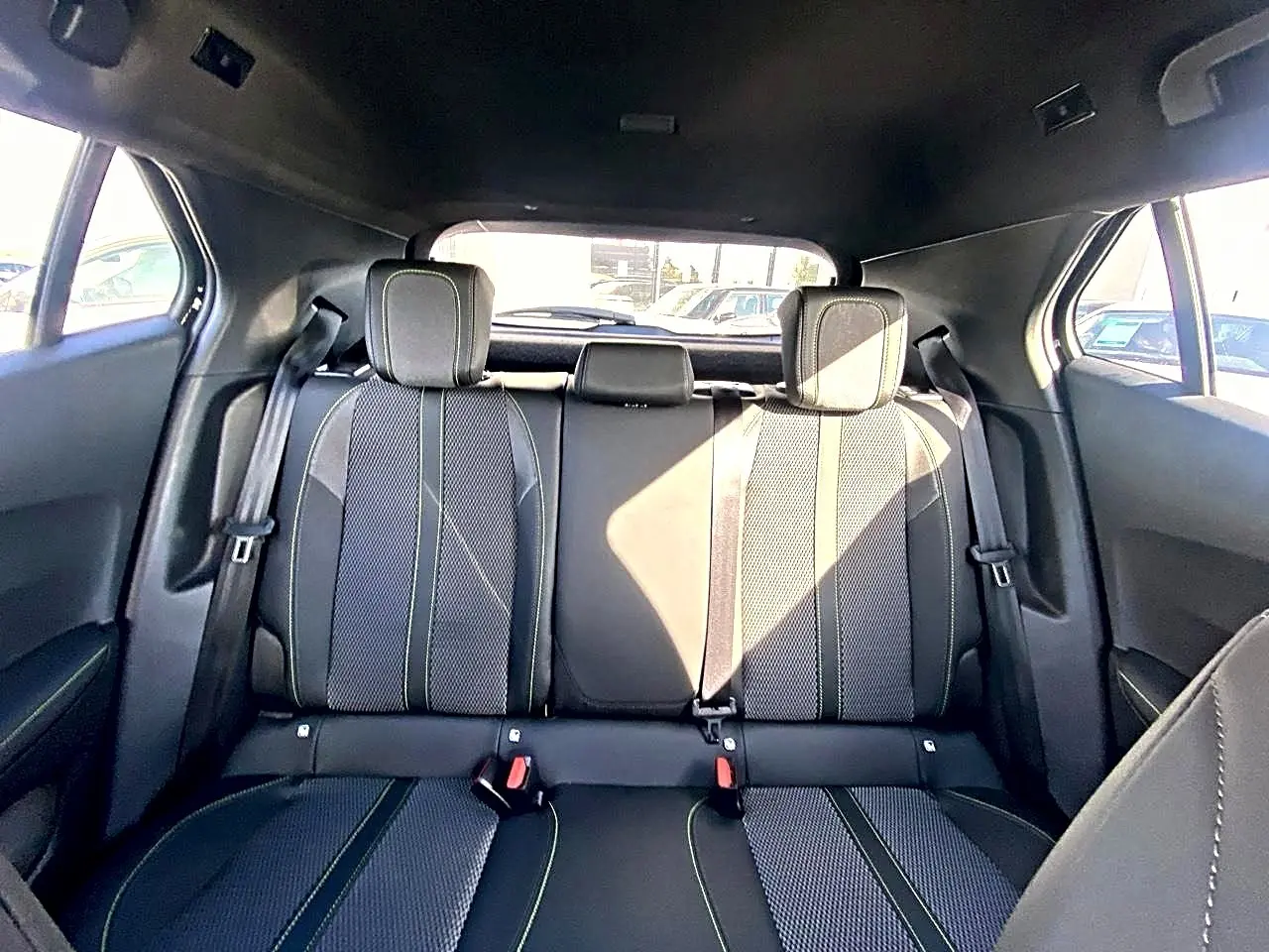 Vue intérieure arrière montrant la banquette noire avec surpiqûres contrastantes du Peugeot 2008 1.2 Hybrid 145 GT.