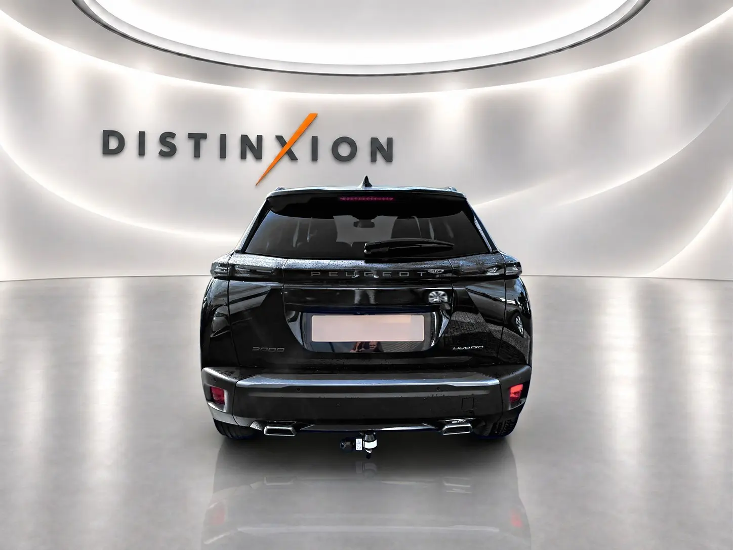 Vue arrière d’un Peugeot 2008 noir 2025 avec attelage, feux LED et becquet arrière dans un showroom lumineux.