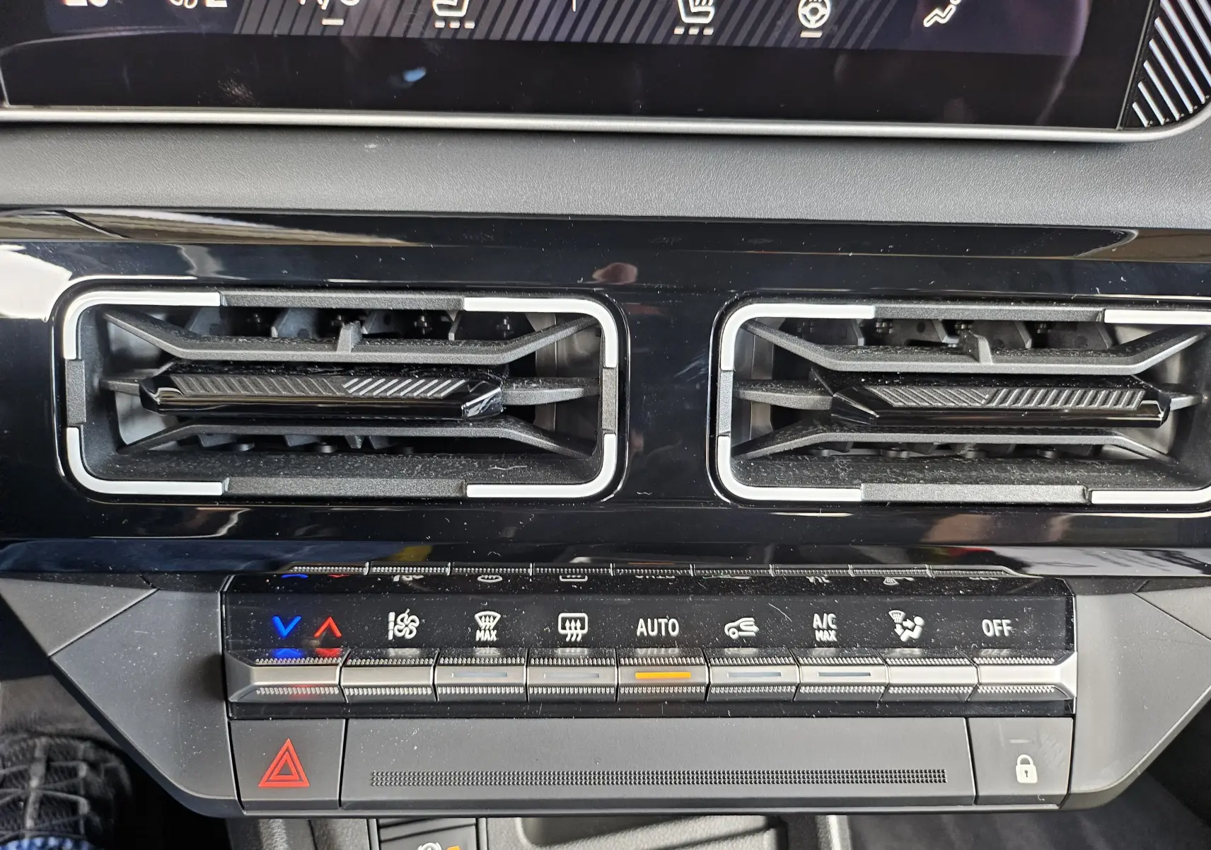 Détail du tableau de bord de la Renault R5 Iconic 2025 montrant les commandes de climatisation et les aérateurs noirs.