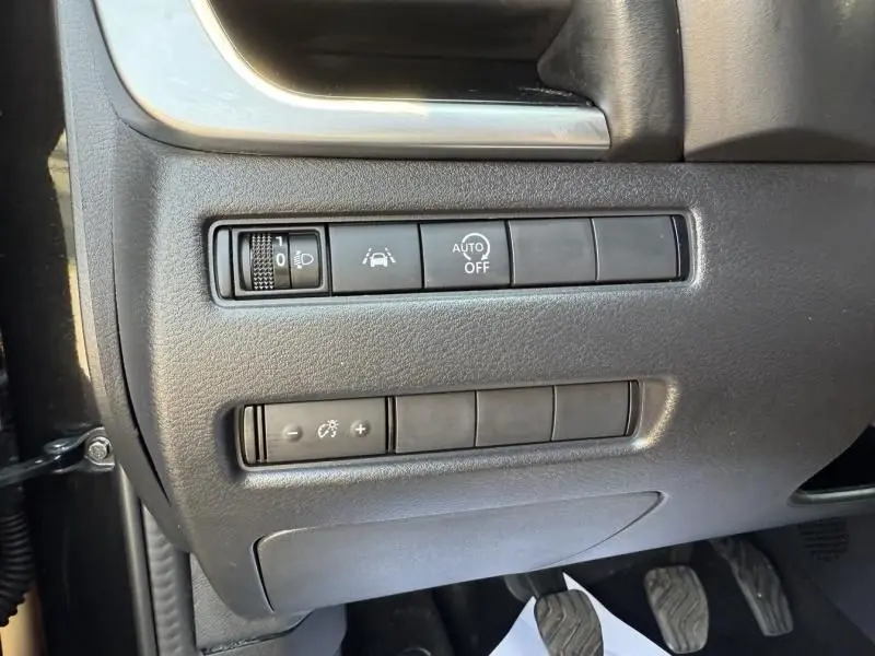 Panneau de commandes latéral gauche intérieur du Nissan Qashqai noir 2023 avec réglages d'éclairage et aides à la conduite.