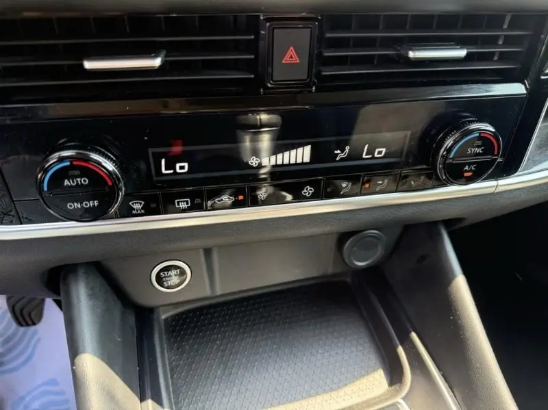 Détail du tableau de bord noir du Nissan Qashqai 1.3 Mild Hybrid 140 N-Connecta 2023, avec commandes climatisation et bouton start-stop visible.