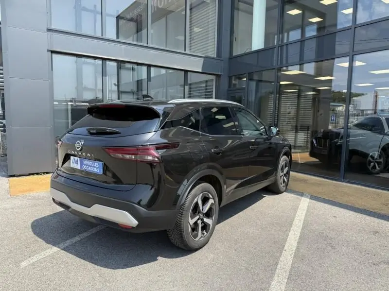 Vue 3/4 arrière droite d'un Nissan Qashqai noir 2023 avec jantes alliage et toit contrasté blanc.