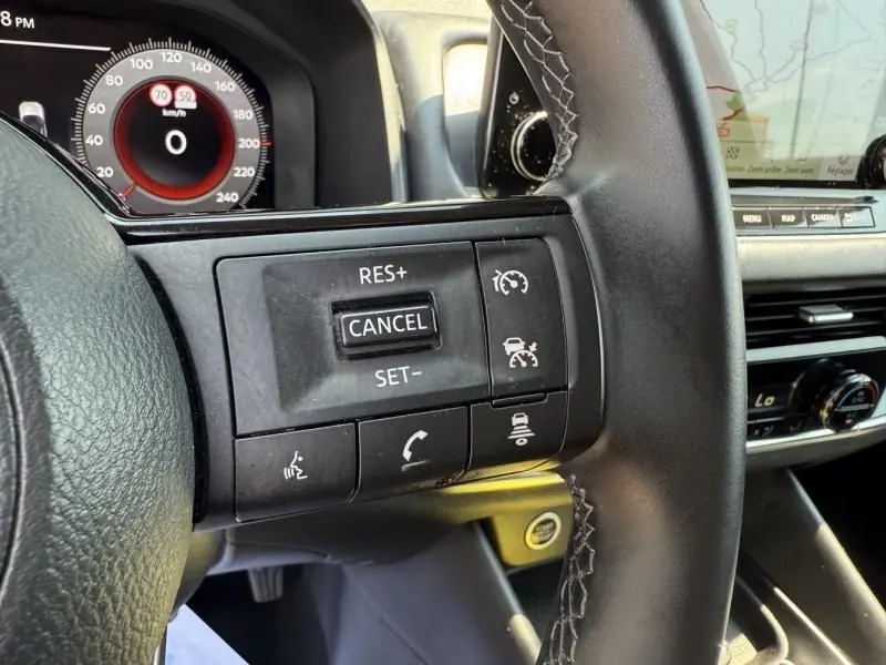 Gros plan sur les commandes au volant côté droit du Nissan Qashqai noir 2023 avec tableau de bord et écran tactile visibles.