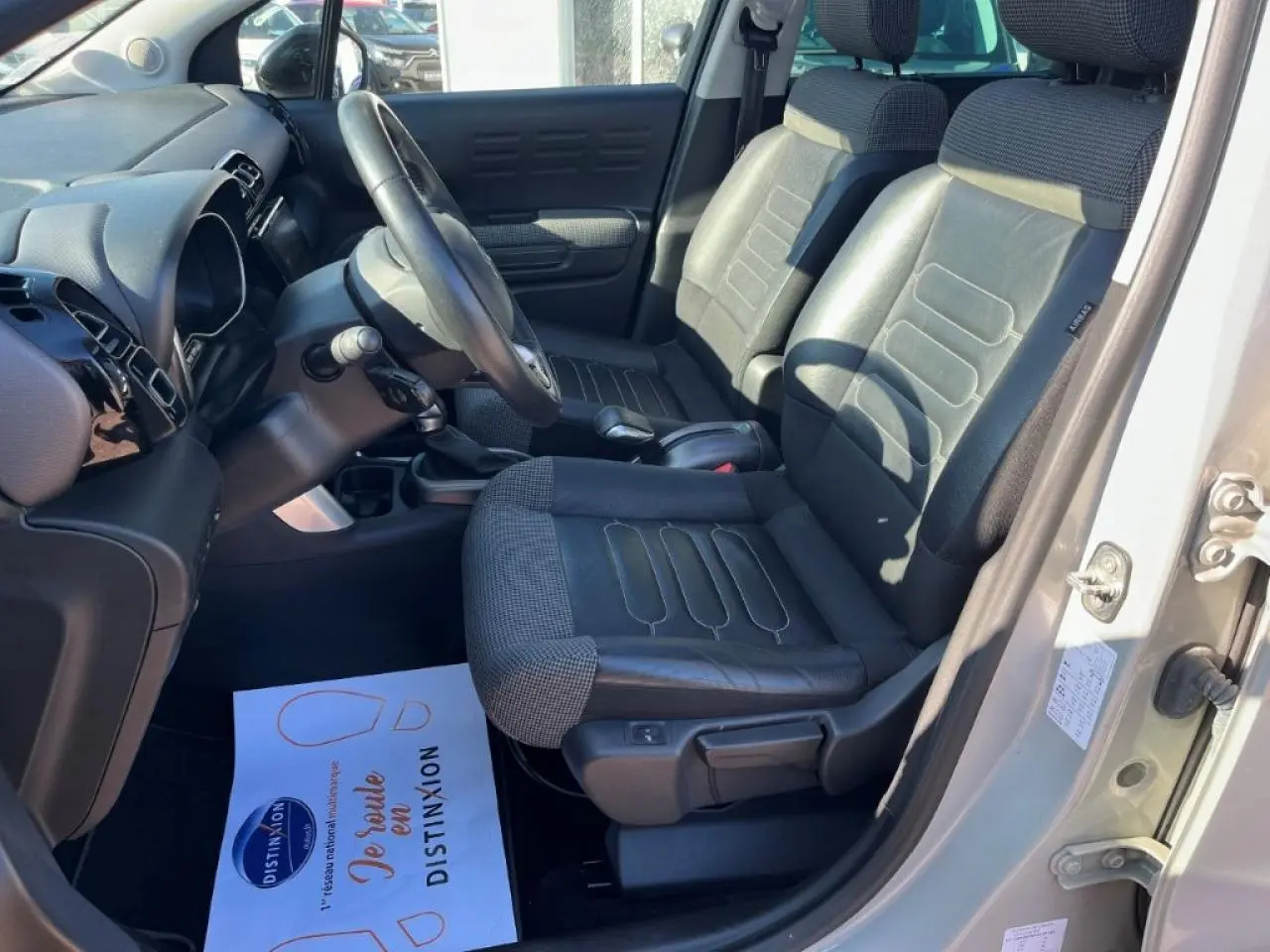 Vue intérieure côté conducteur du Citroën C3 Aircross 2019, sièges cuir/tissu noirs avec tableau de bord moderne.