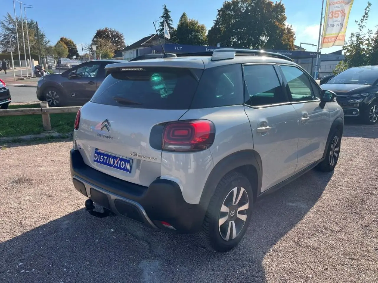 Vue 3/4 arrière droite d'un Citroën C3 Aircross beige avec attelage col de cygne et toit ouvrant panoramique.