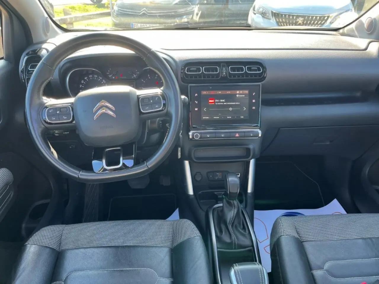 Vue intérieure avant du Citroën C3 Aircross 2019, tableau de bord noir avec écran tactile et volant multifonction.