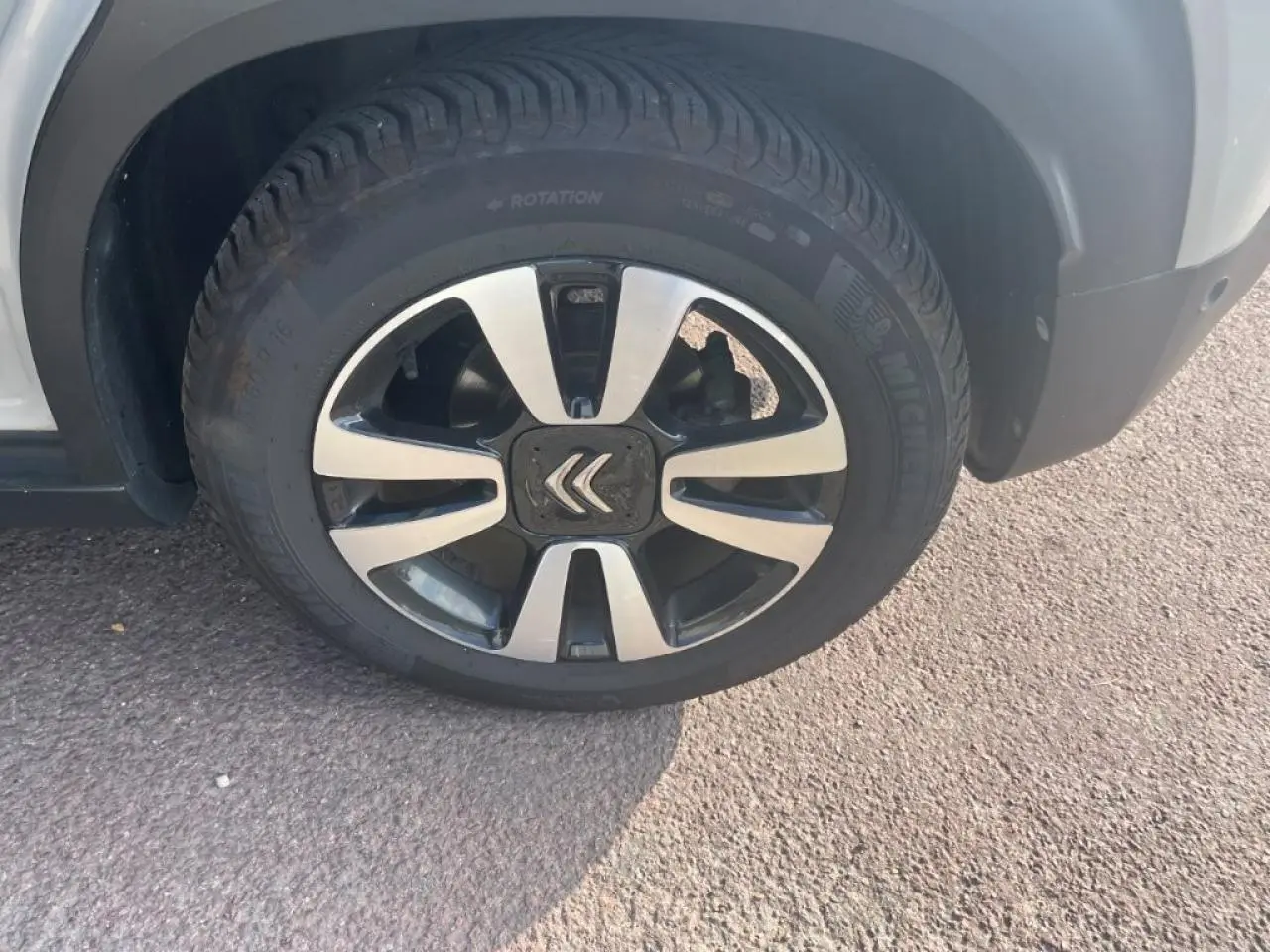 Gros plan sur la roue avant gauche avec jante alliage diamantée et logo Citroën sur un C3 Aircross beige.