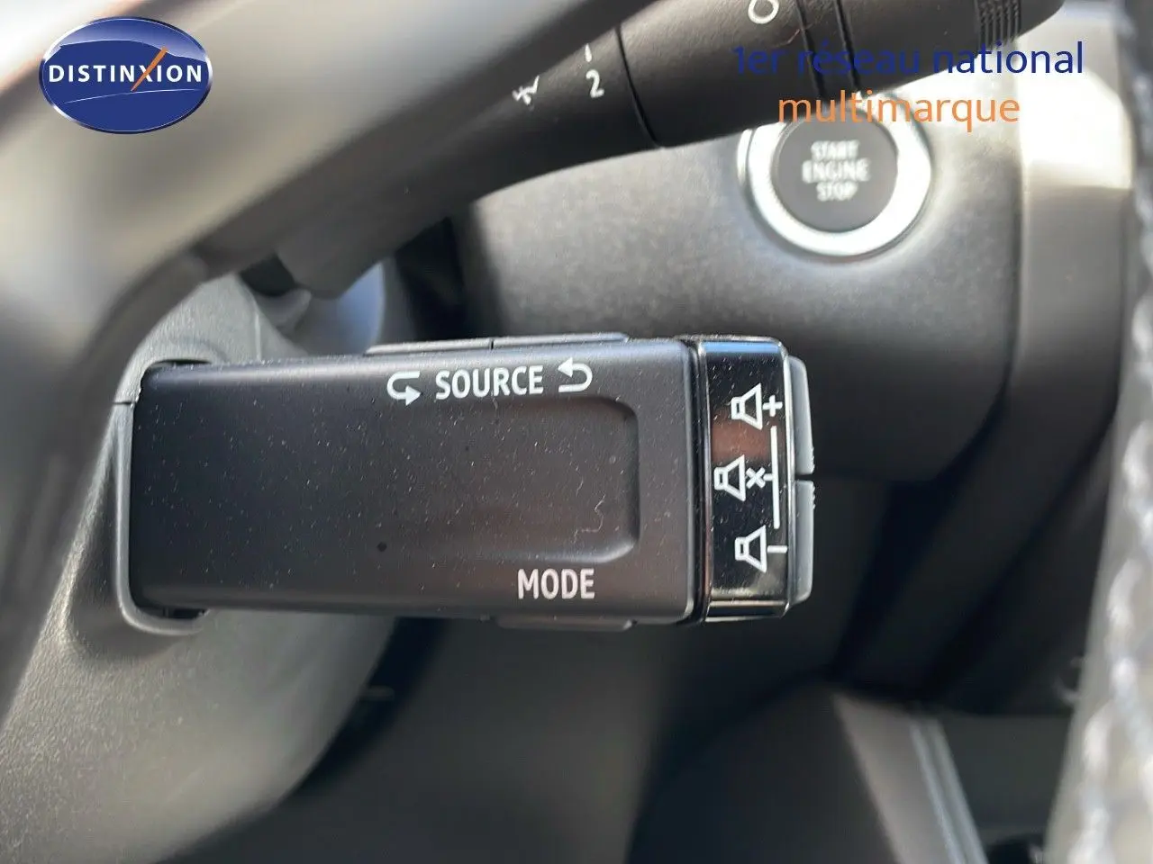 Gros plan sur la commande au volant du Renault Captur 2025, avec bouton source et mode, volant en cuir noir.