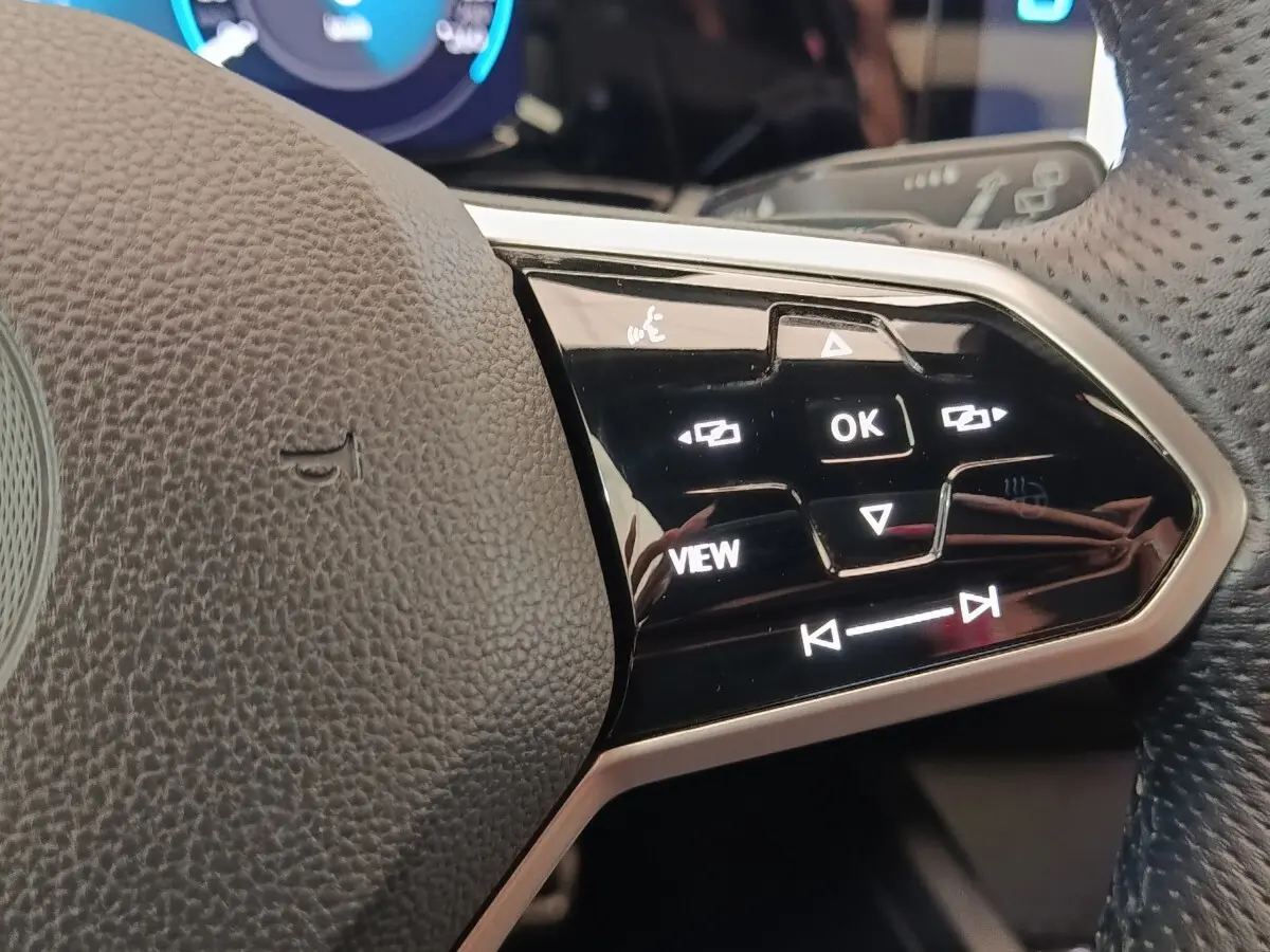 Gros plan sur les commandes noires et argentées du volant de la Volkswagen Golf 1.5 eTSI R-Line, côté droit.