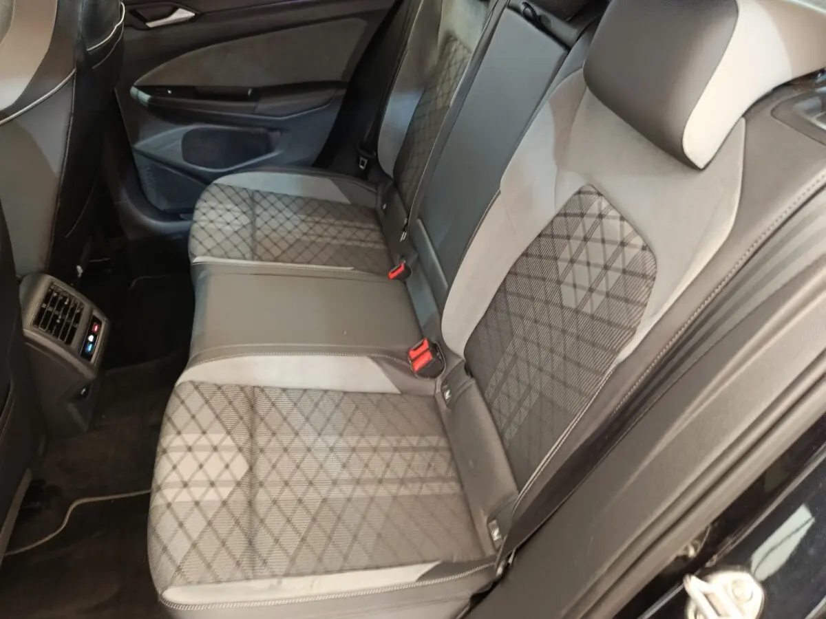 Vue intérieure côté arrière droit de la banquette arrière noire et grise avec motif quadrillé de la Volkswagen Golf 1.5 eTSI R-Line.
