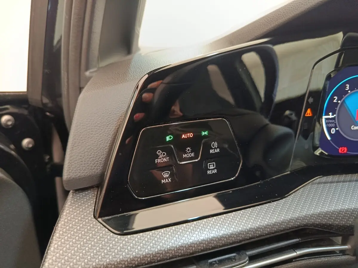 Détail du tableau de bord noir de la Volkswagen Golf 1.5 eTSI 2021 avec commandes d'éclairage et affichage digital partiel.
