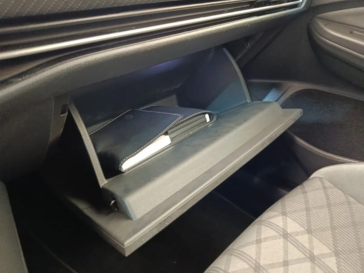 Gant de boîte à gants ouvert côté passager dans l’habitacle noir d’une Volkswagen Golf 1.5 eTSI R-Line.