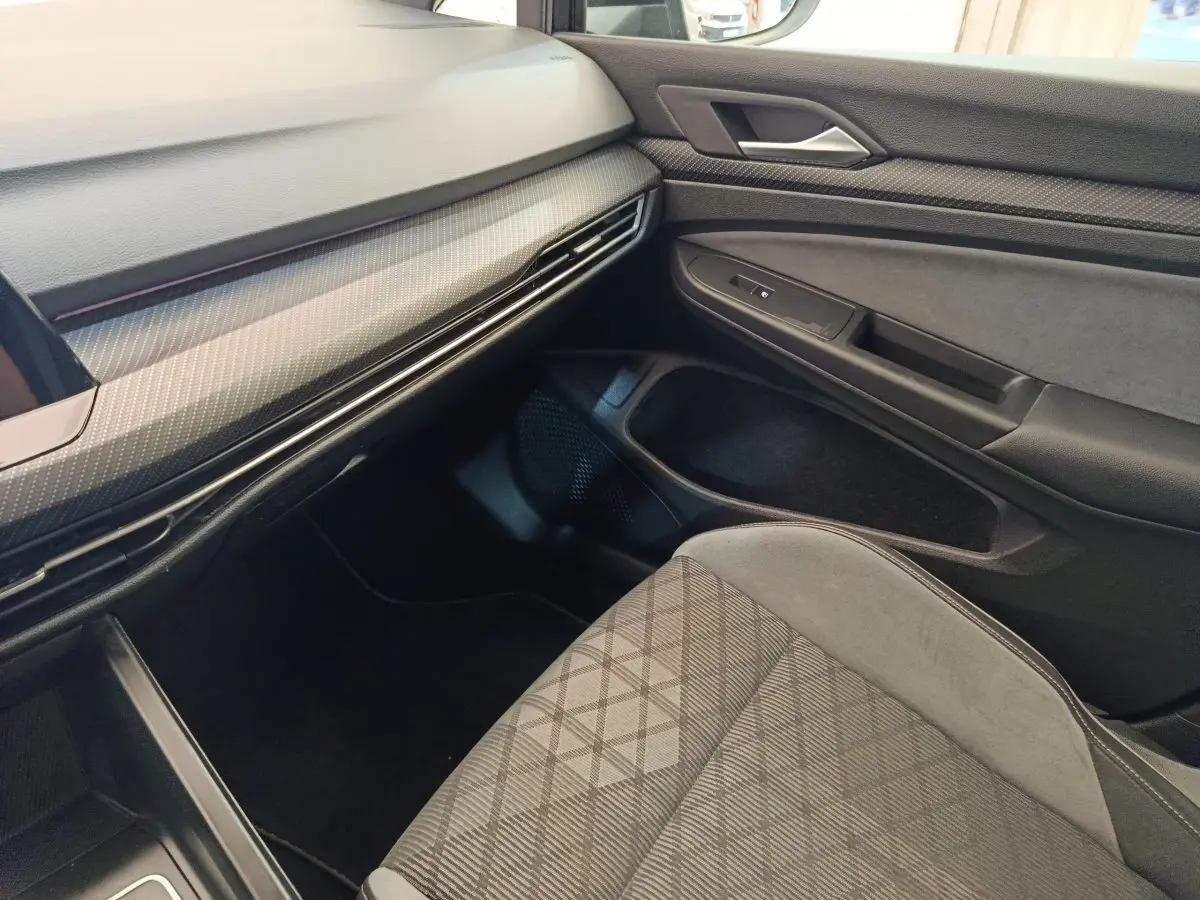Vue intérieure côté passager de la Volkswagen Golf 1.5 eTSI R-Line 2021, avec siège tissu gris et tableau de bord noir.