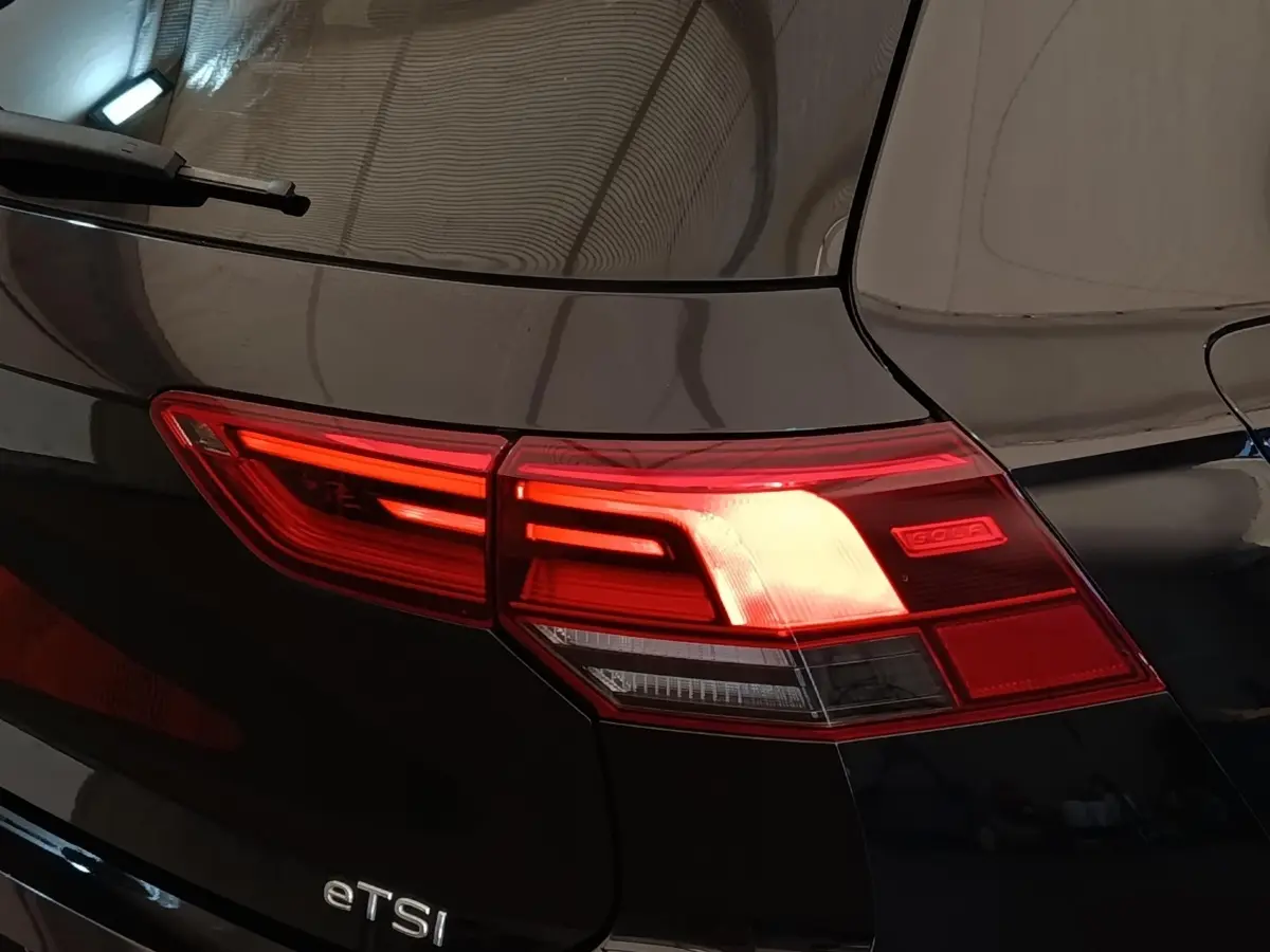 Feu arrière droit allumé d'une Volkswagen Golf noire 1.5 eTSI R-Line, vue rapprochée sur le coffre.