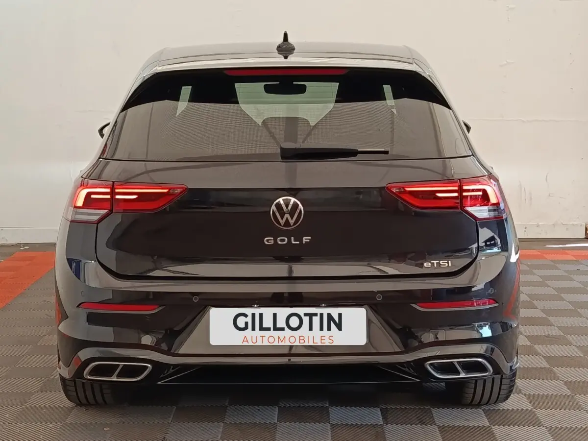 Vue arrière d'une Volkswagen Golf noire 1.5 eTSI avec feux LED et double sortie d'échappement rectangulaire.