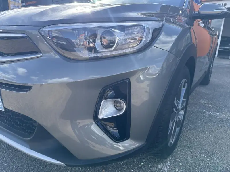 Gros plan sur l'avant droit du KIA Stonic brun Sienne, mettant en valeur le phare et le feu antibrouillard.