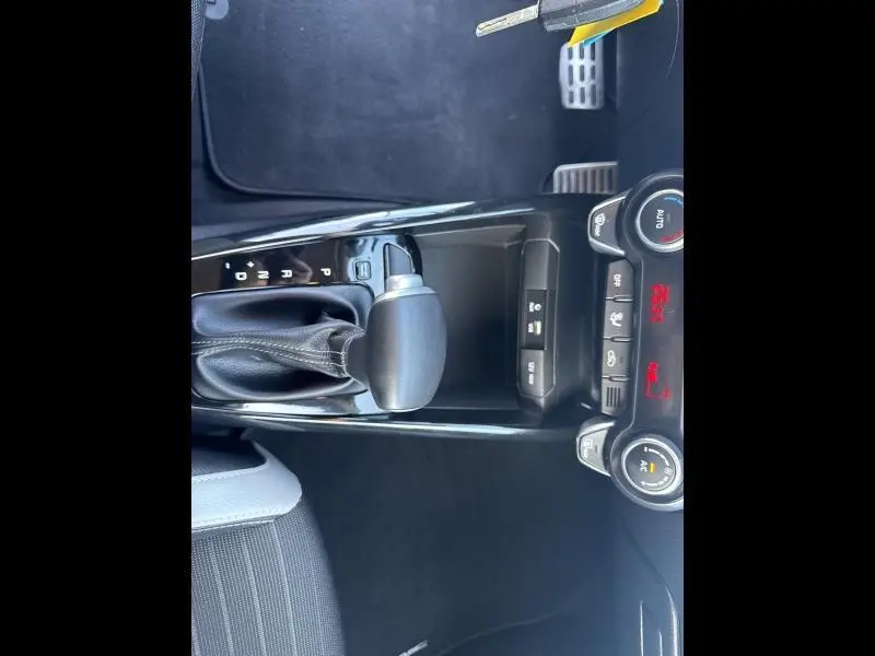 Vue rapprochée de la console centrale du Kia Stonic brun Sienne 2019, avec levier de vitesse automatique en cuir et commandes climatisation.