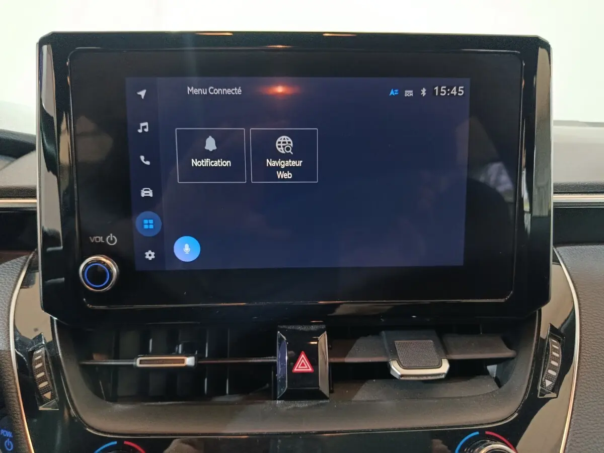 Écran tactile central noir affichant le menu connecté dans l'habitacle de la Toyota Corolla hybride 2022.