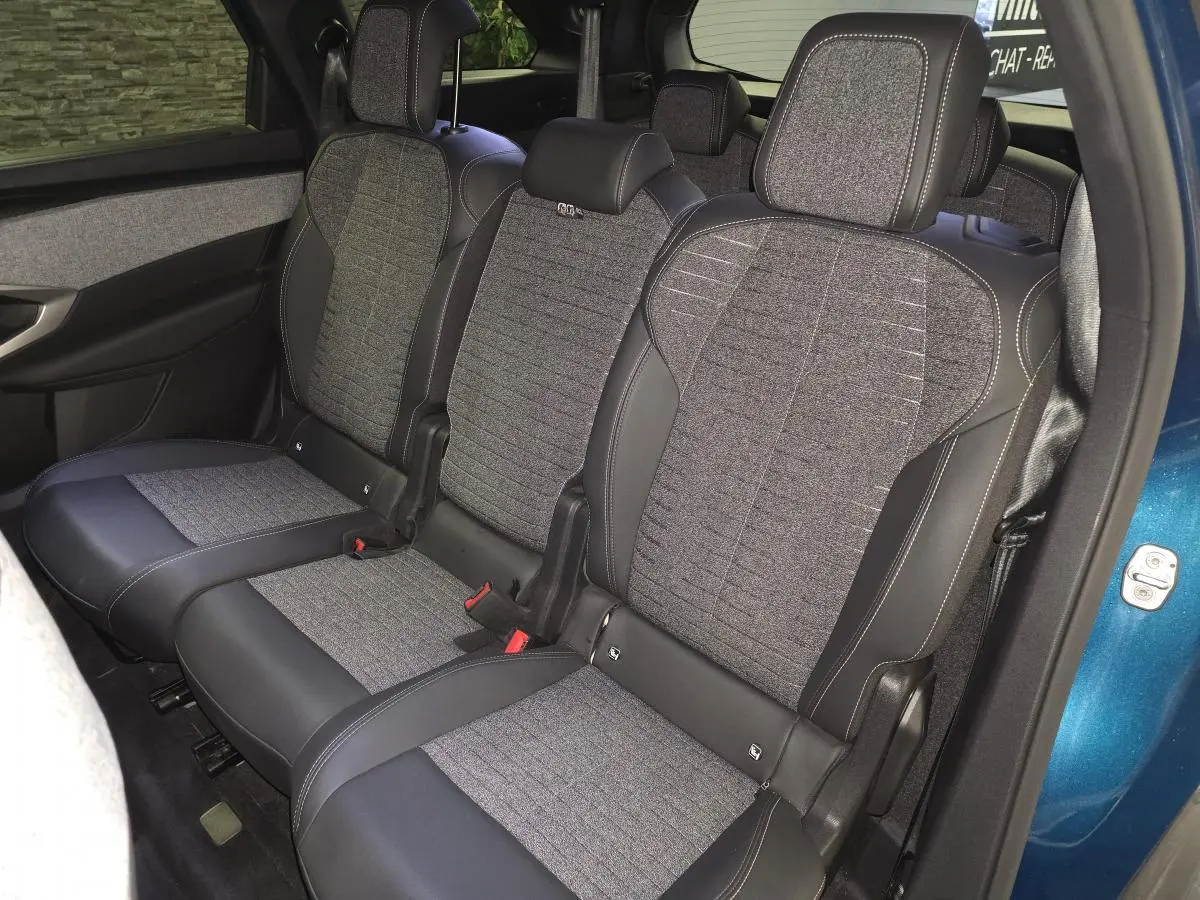 Vue intérieure côté droit des sièges arrière en tissu gris et cuir noir du Peugeot 5008 bleu 2025.