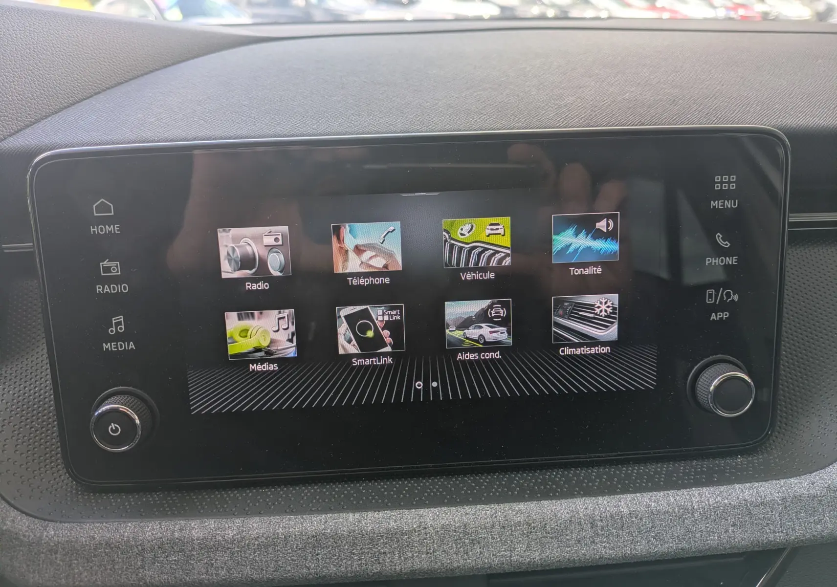 Écran tactile central de la Skoda Scala gris reflex 2025 affichant les menus radio, téléphone, véhicule et climatisation.