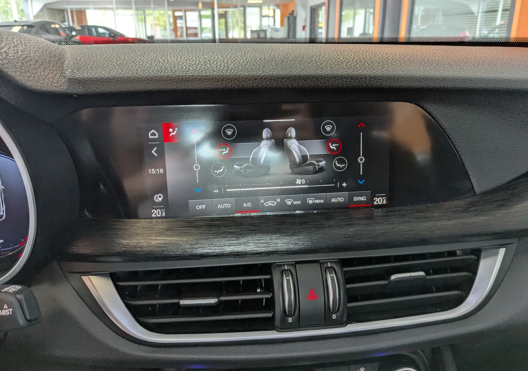 Écran tactile central affichant la climatisation avec réglages des sièges dans l'Alfa Romeo Stelvio noir 2023.