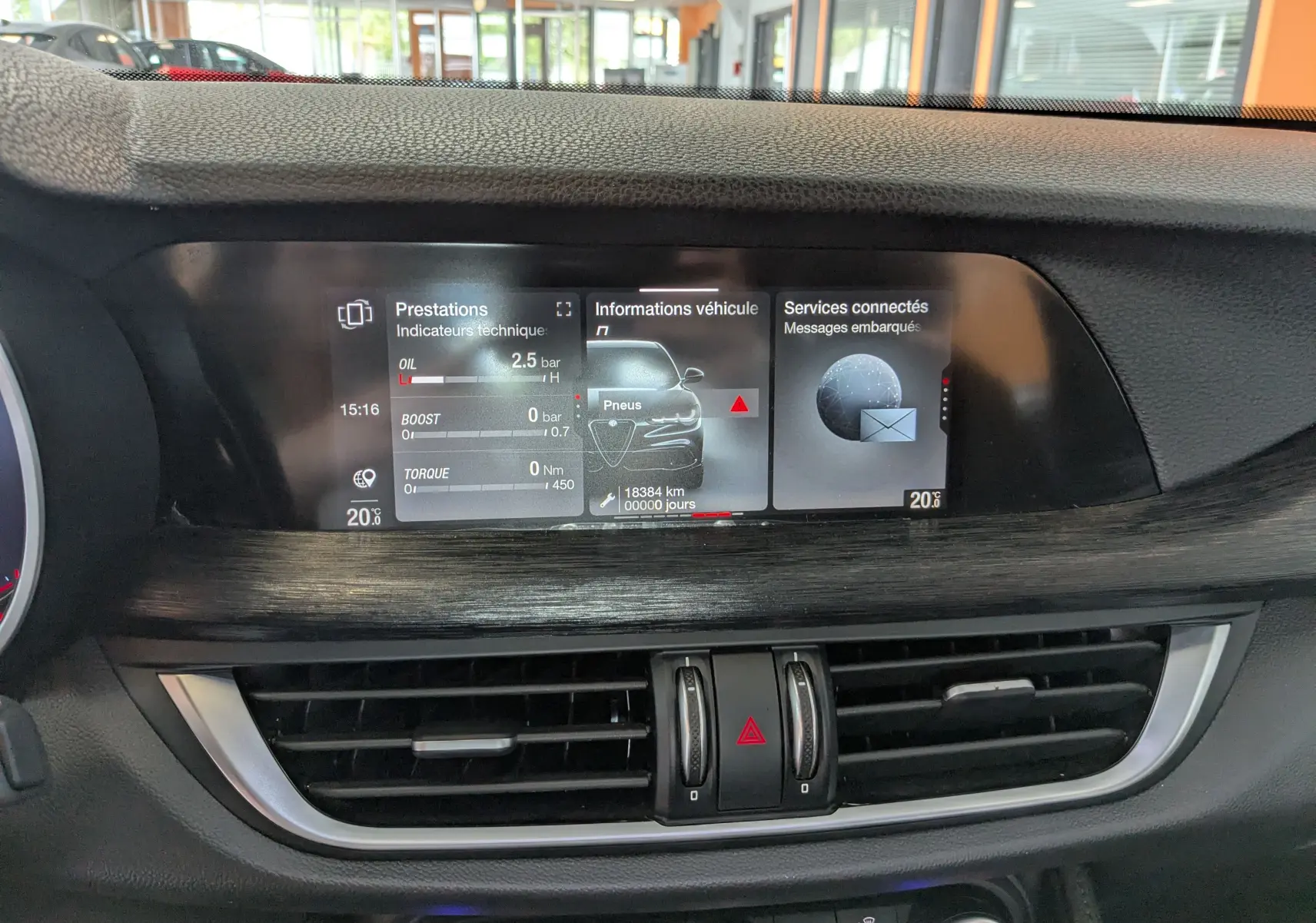 Vue rapprochée de l'écran central multimédia de l'Alfa Romeo Stelvio 2023, affichant les informations techniques et connectées.