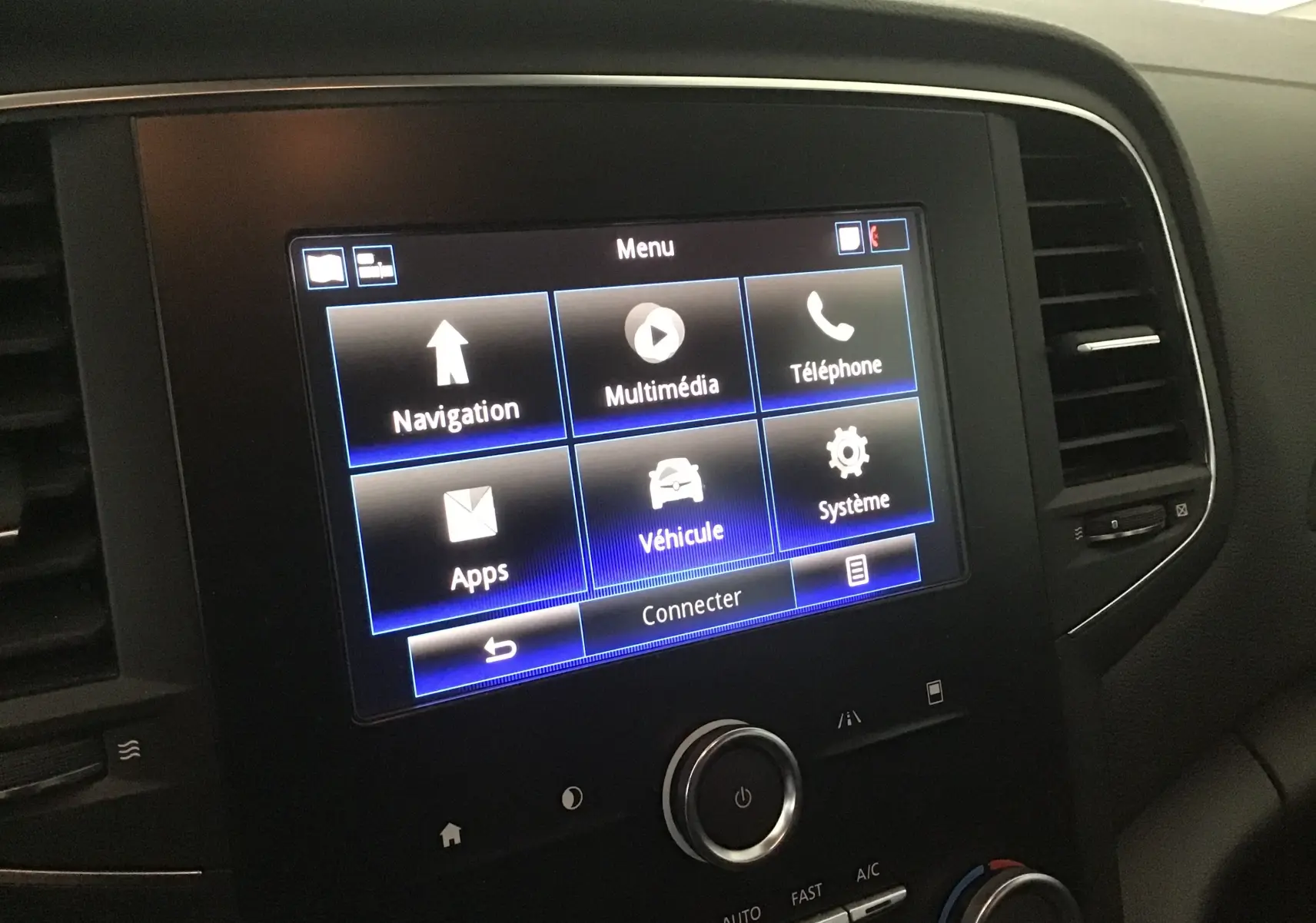Écran tactile central du tableau de bord de la Renault Mégane IV Berline 2019 avec menu multimédia et navigation visible.